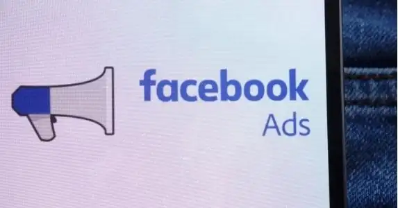 Móvil en el bolsillo de un pantalón con la pantalla abierta mostrando el logotipo de Facebook Ads.